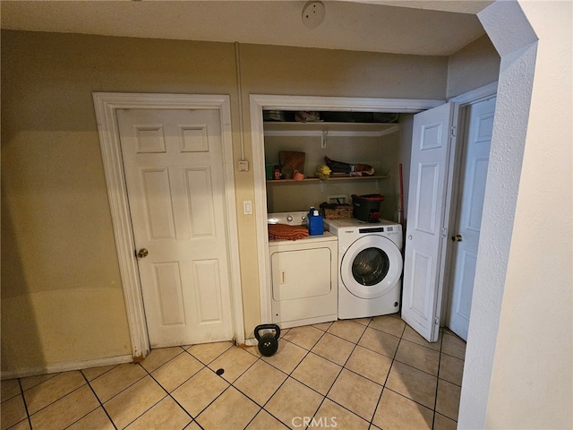 laundry area featuring washer and clothes dryer and light tile patterned flooring