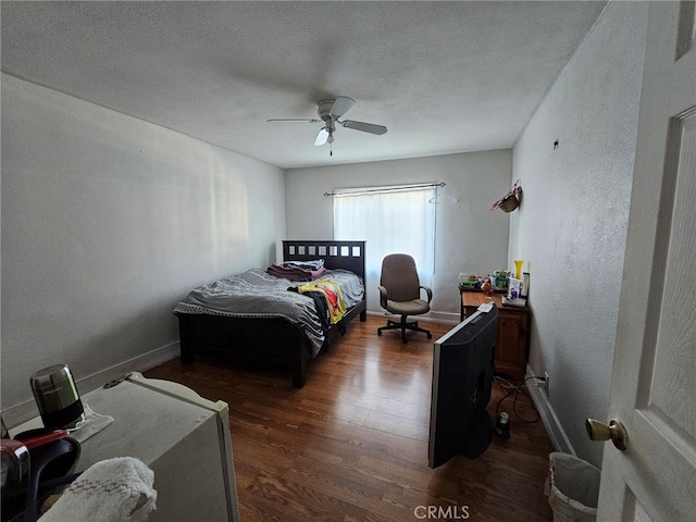 bedroom featuring ceiling fan, a textured ceiling, and dark hardwood / wood-style flooring