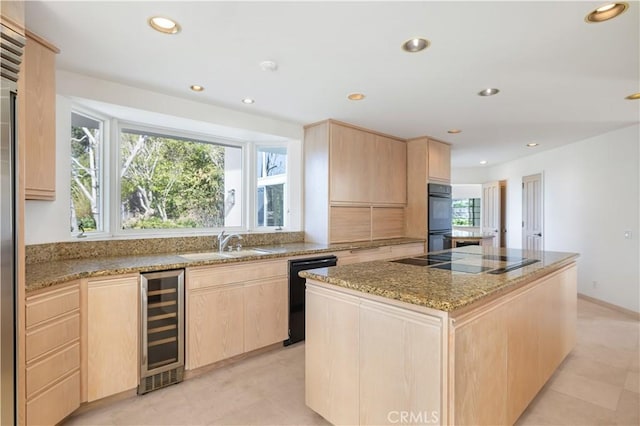 kitchen with black appliances, wine cooler, light brown cabinets, and a center island