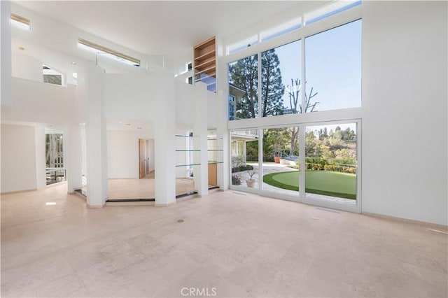 unfurnished living room featuring visible vents and a towering ceiling