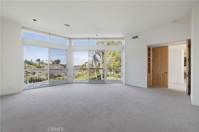 empty room with light carpet, visible vents, and baseboards