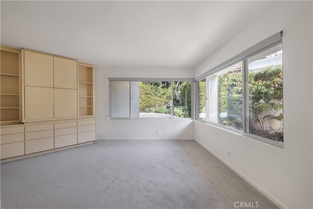 interior space featuring light colored carpet and baseboards