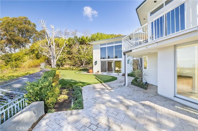 view of yard featuring a balcony and a patio