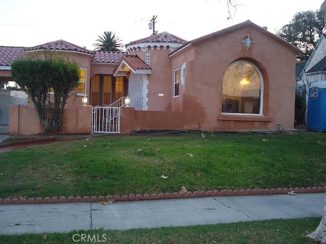 mediterranean / spanish-style home featuring a front lawn