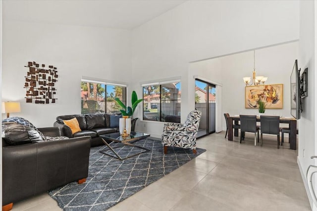 living room featuring a high ceiling, a wealth of natural light, an inviting chandelier, and concrete flooring