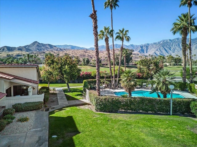 view of home's community featuring a swimming pool, a mountain view, and a yard