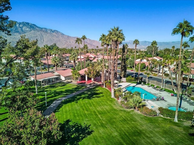 view of swimming pool featuring a mountain view and a lawn