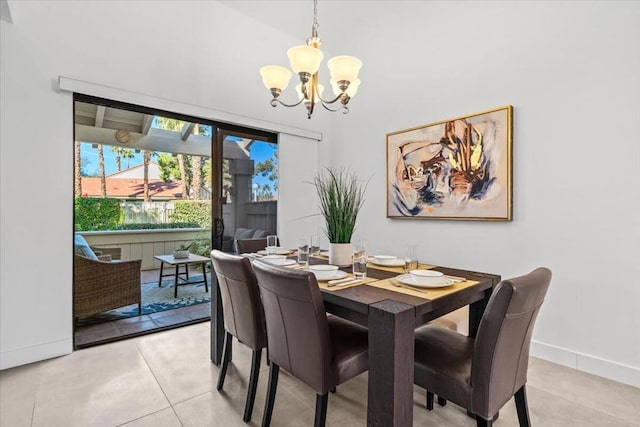 tiled dining room with a chandelier