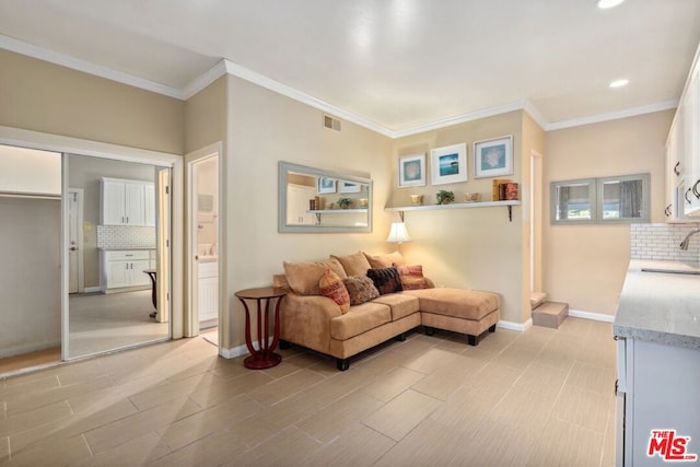 living room featuring sink and crown molding