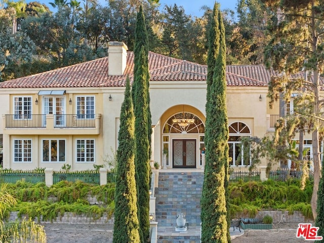 mediterranean / spanish-style house featuring french doors and a balcony