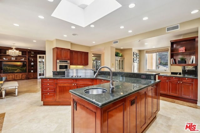 kitchen featuring an inviting chandelier, stainless steel oven, a spacious island, and sink