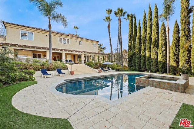 view of pool with a patio area and an in ground hot tub