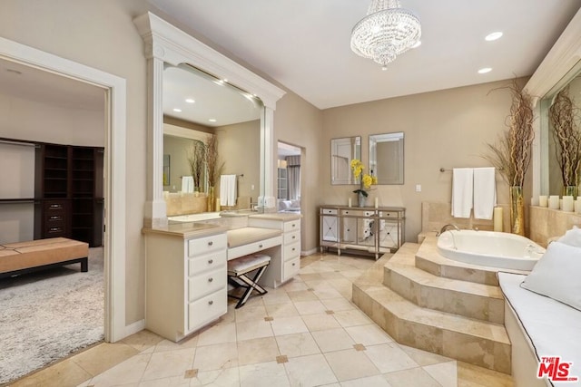 bathroom featuring vanity, tile patterned floors, an inviting chandelier, and a relaxing tiled tub