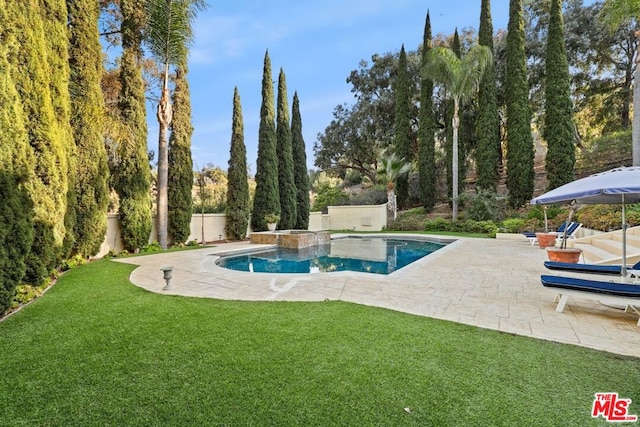 view of swimming pool featuring a lawn, a hot tub, and a patio area