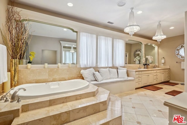 bathroom with vanity, tile patterned flooring, and tiled tub