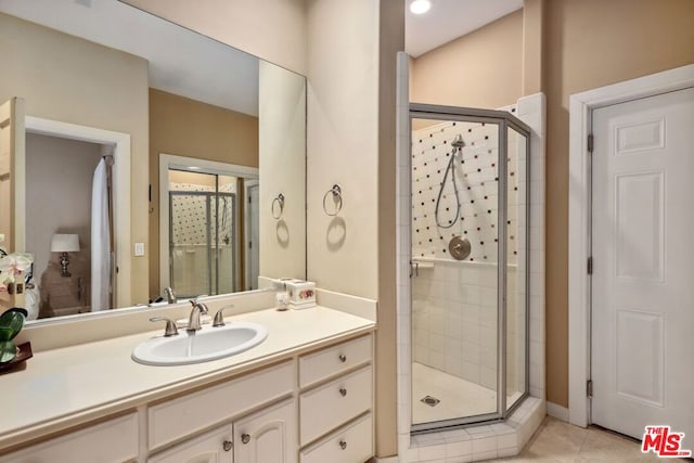 bathroom with tile patterned floors, vanity, and an enclosed shower