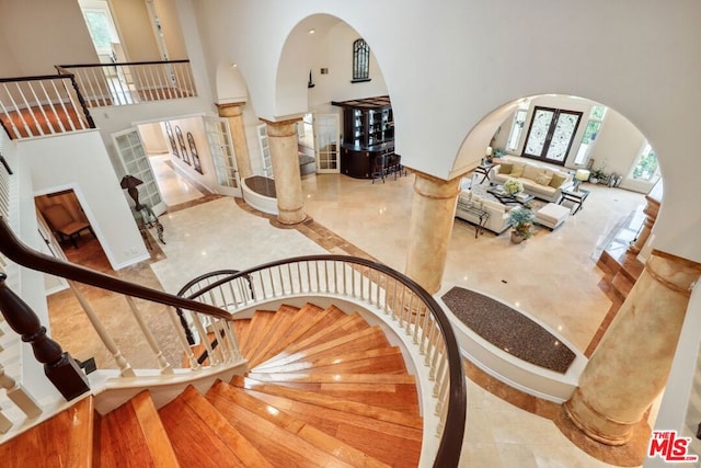 stairway featuring french doors and a towering ceiling