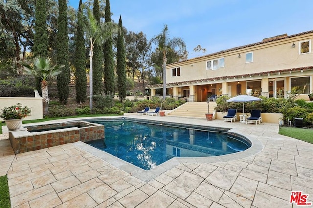 view of pool featuring a patio area and an in ground hot tub