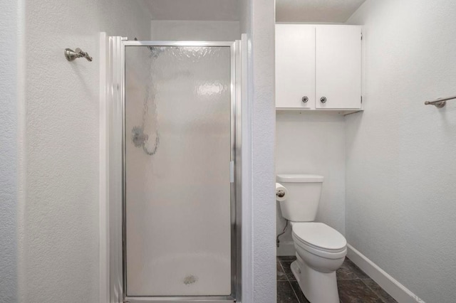 bathroom featuring toilet and a shower with door