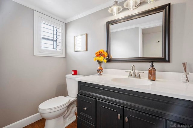 bathroom featuring hardwood / wood-style flooring, crown molding, vanity, and toilet