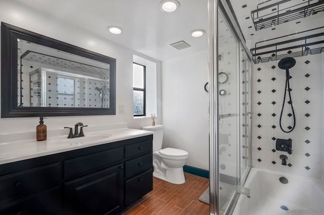 full bathroom featuring toilet, vanity, and bath / shower combo with glass door