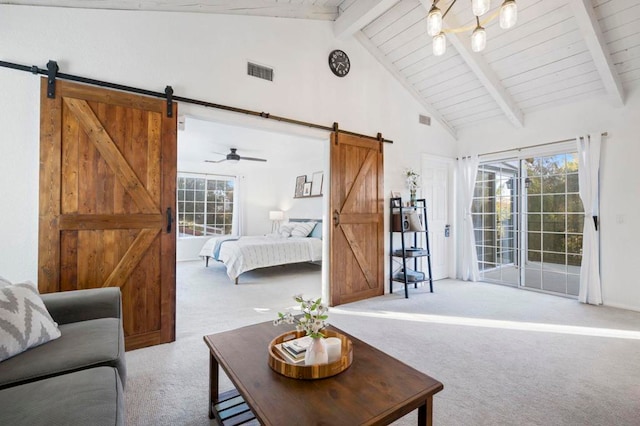 living room featuring light colored carpet, ceiling fan, a barn door, and a healthy amount of sunlight