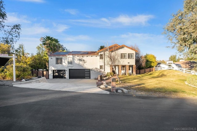 mediterranean / spanish-style home with solar panels, a front yard, and a garage