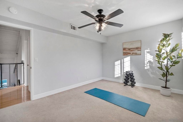 exercise area featuring ceiling fan and light carpet