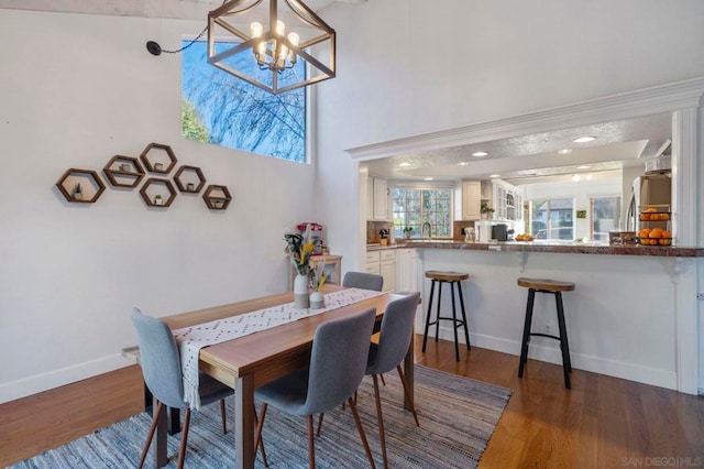 dining space with dark wood-type flooring and a notable chandelier