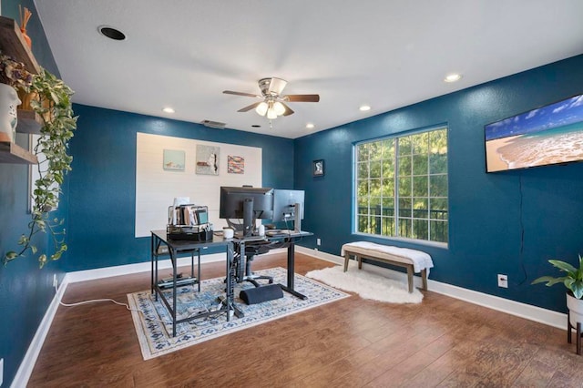 home office with ceiling fan and dark hardwood / wood-style flooring