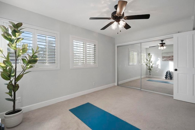 workout area with ceiling fan and carpet