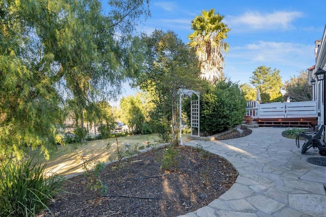 view of yard featuring a patio area and a wooden deck