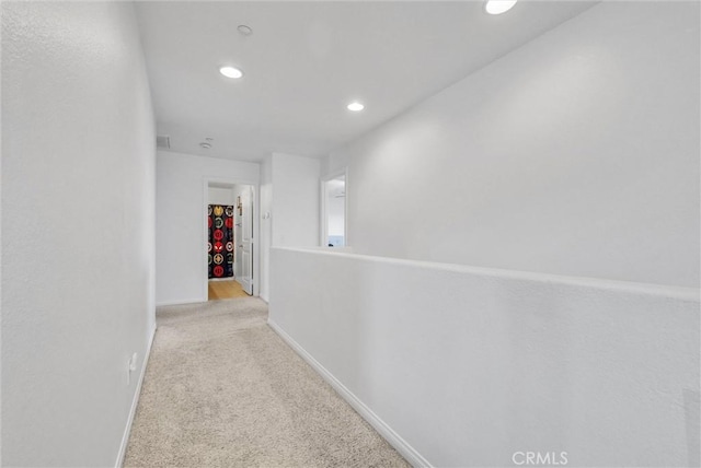 hallway featuring light colored carpet