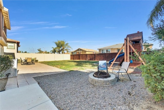 view of yard with an outdoor fire pit, a patio area, and a playground