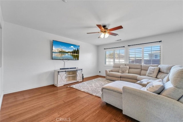 living room featuring hardwood / wood-style floors and ceiling fan