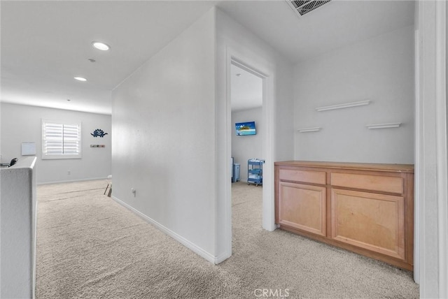 corridor featuring light colored carpet