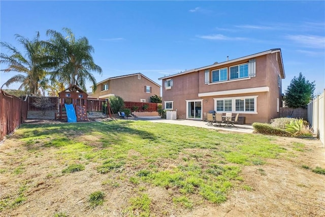 rear view of house featuring a lawn, a playground, and a patio area