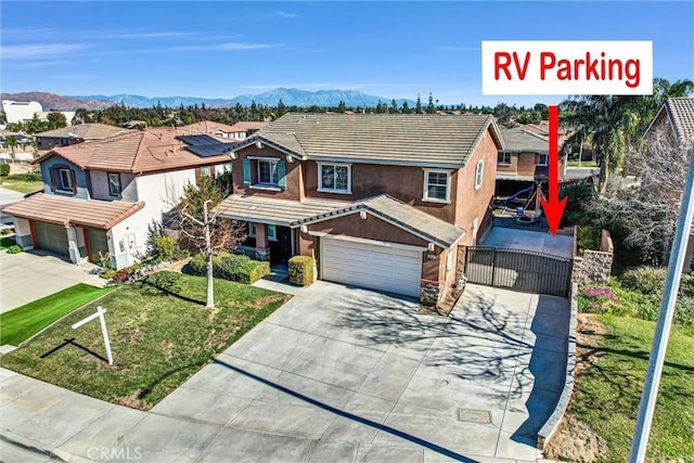 view of front of house featuring a garage, a front yard, and a mountain view