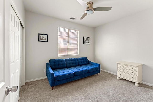 living area with light colored carpet and ceiling fan