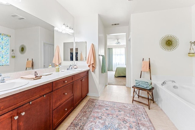 bathroom with vanity, a relaxing tiled tub, tile patterned floors, and ceiling fan