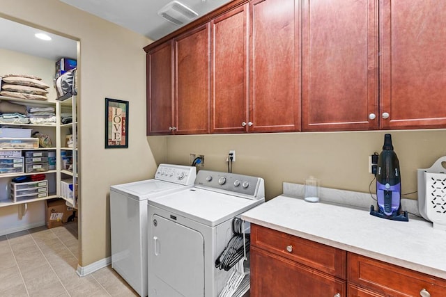 washroom featuring washer and clothes dryer, cabinets, and light tile patterned flooring