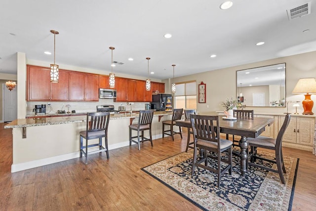 dining room featuring sink and light hardwood / wood-style flooring