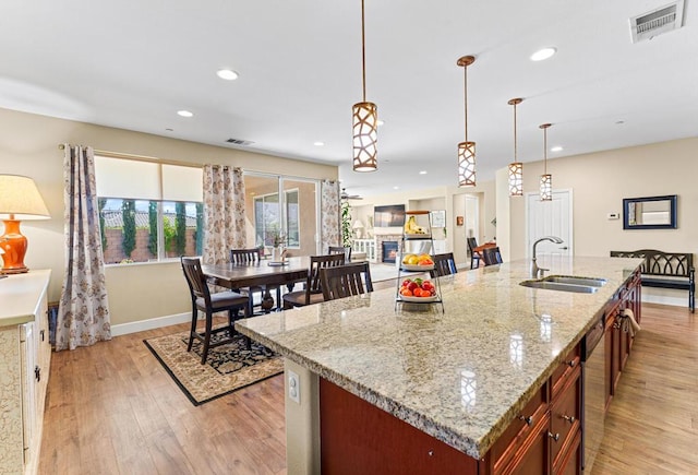 kitchen with hanging light fixtures, sink, and a center island with sink