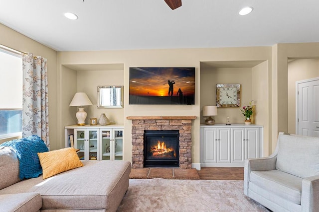 living room featuring ceiling fan and a fireplace