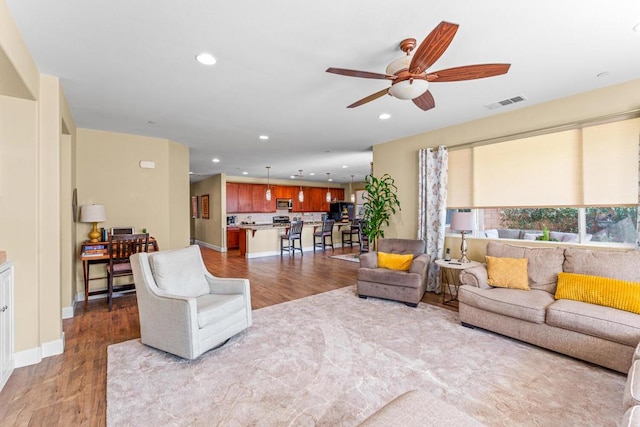 living room featuring light hardwood / wood-style flooring and ceiling fan