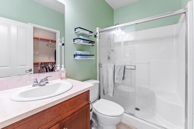 bathroom with vanity, toilet, and a shower with shower door