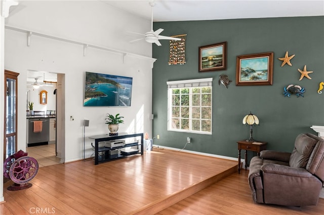 living room featuring lofted ceiling, ceiling fan, and light wood-type flooring