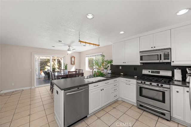 kitchen with white cabinetry, sink, ceiling fan, kitchen peninsula, and stainless steel appliances