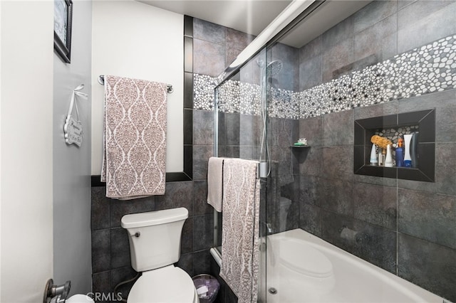 bathroom with tile walls and toilet