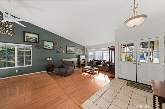 living room featuring vaulted ceiling, light hardwood / wood-style floors, french doors, and ceiling fan